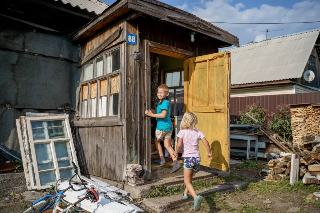 Маша с&nbsp;братом Артём Чукавиным забегают в&nbsp;свой дом после прогулки, село Мочище, Новосибирская область. Их&nbsp;мама Оксана воспитывает шестерых детей, у&nbsp;одного ребёнка паллиативный диагноз. Центр «Вместе» приобрели для семьи уголь и&nbsp;дрова на&nbsp;зиму, чтобы дети не&nbsp;оказались в&nbsp;приюте. Фото: Дмитрий Яцюк.