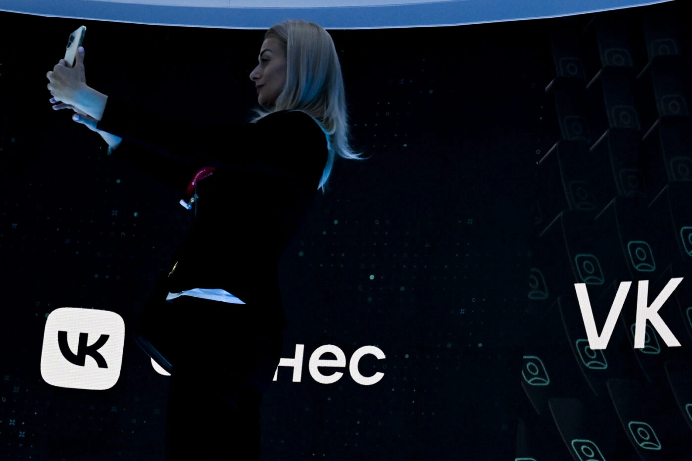 Участница ПМЭФ в&nbsp;Санкт-Петербурге на&nbsp;фоне сенда VK
