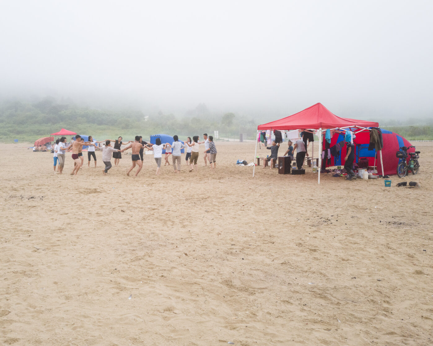 Отдыхающие водят хоровод под северокорейский хит 2024 года «Добрый отец», посвященный лидеру Ким Чен Ыну на&nbsp;пляже в&nbsp;Расоне